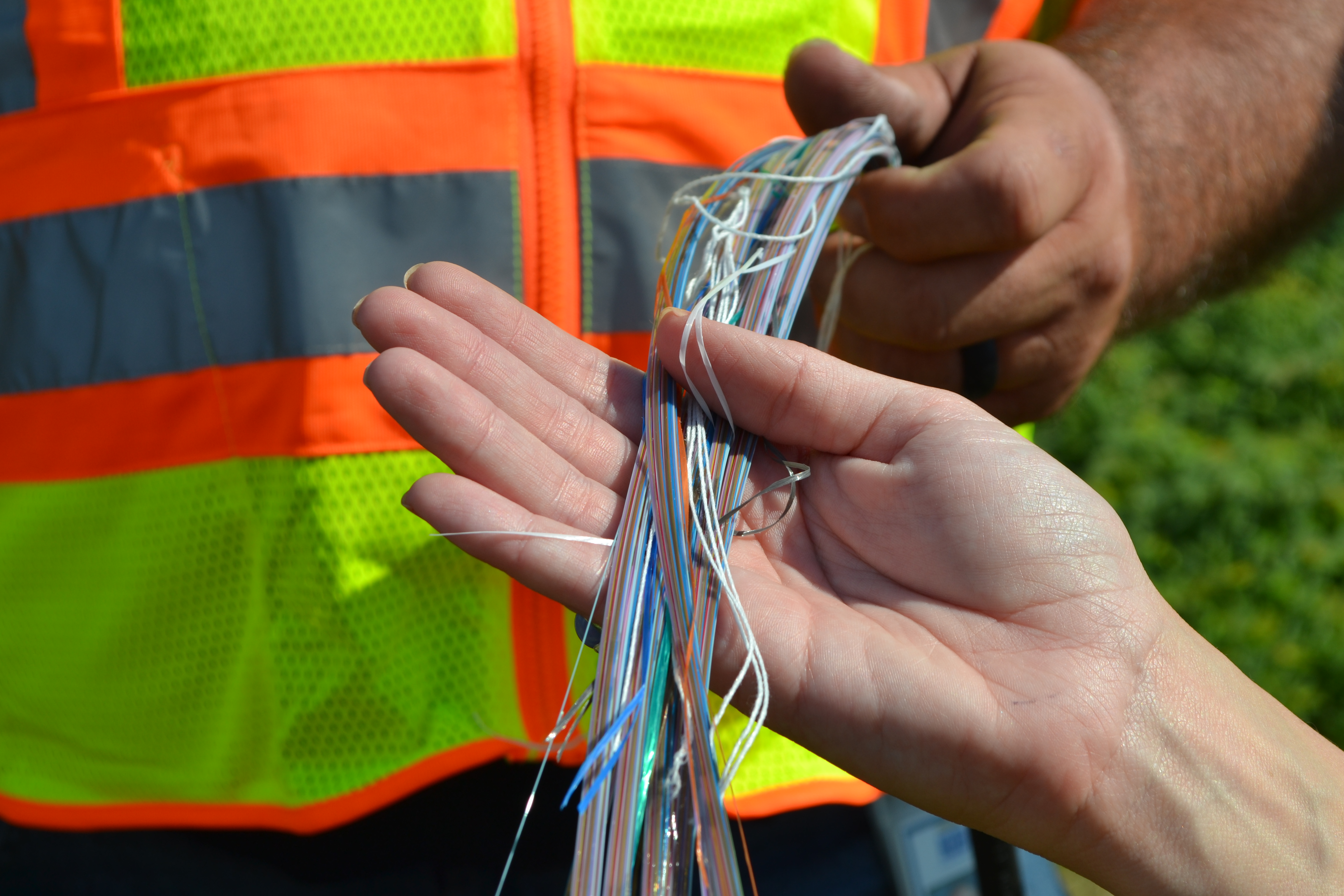 a KUB Fiber Team Member showing a customer what fiber lines look like, Strands of glass like